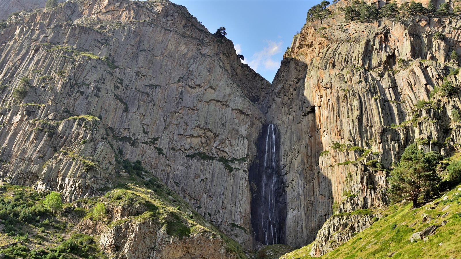 Tall waterfall dropping through a rocky gorge